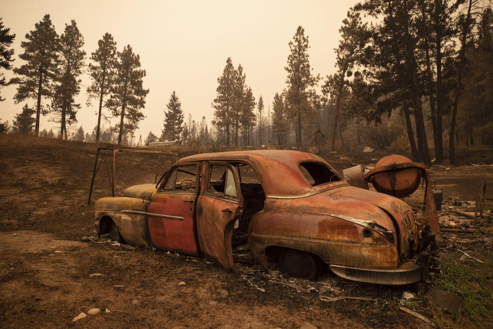 The remains of a classic car sits on a property destroyed by the White Rock Lake wildfire in Monte Lake, east of Kamloops, British Columbia, Saturday, Aug. 14, 2021. (Darryl Dyck/The Canadian Press via AP)