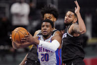 Detroit Pistons guard Josh Jackson (20) drives to the basket as Sacramento Kings forward Marvin Bagley III, left, and guard Cory Joseph defends during the second half of an NBA basketball game, Friday, Feb. 26, 2021, in Detroit. (AP Photo/Carlos Osorio)