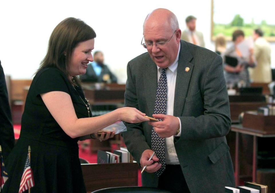 Rep. Tricia Ann Cotham gives Rep. Bill Brawley a homemade crossover cookie before the North Carolina House session in the Legislative Building in Raleigh, N.C., Wednesday, April 29, 2015.