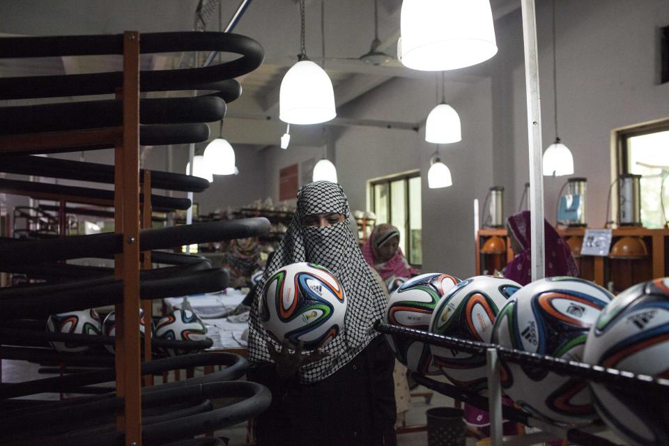 An employee checks the shape of a ball inside the soccer ball factory that produces official match balls for the 2014 World Cup in Brazil, in Sialkot, Punjab province