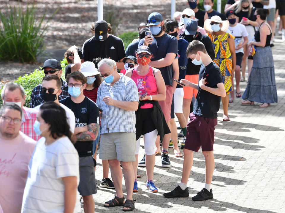 People standing in line waiting to get the Covid vaccine in Queensland.