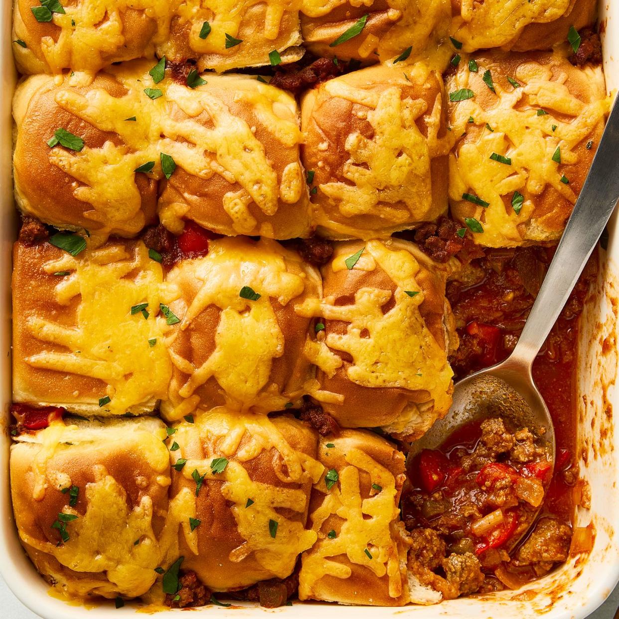 casserole dish with sloppy joe mixture topped with mini buns and melted cheese