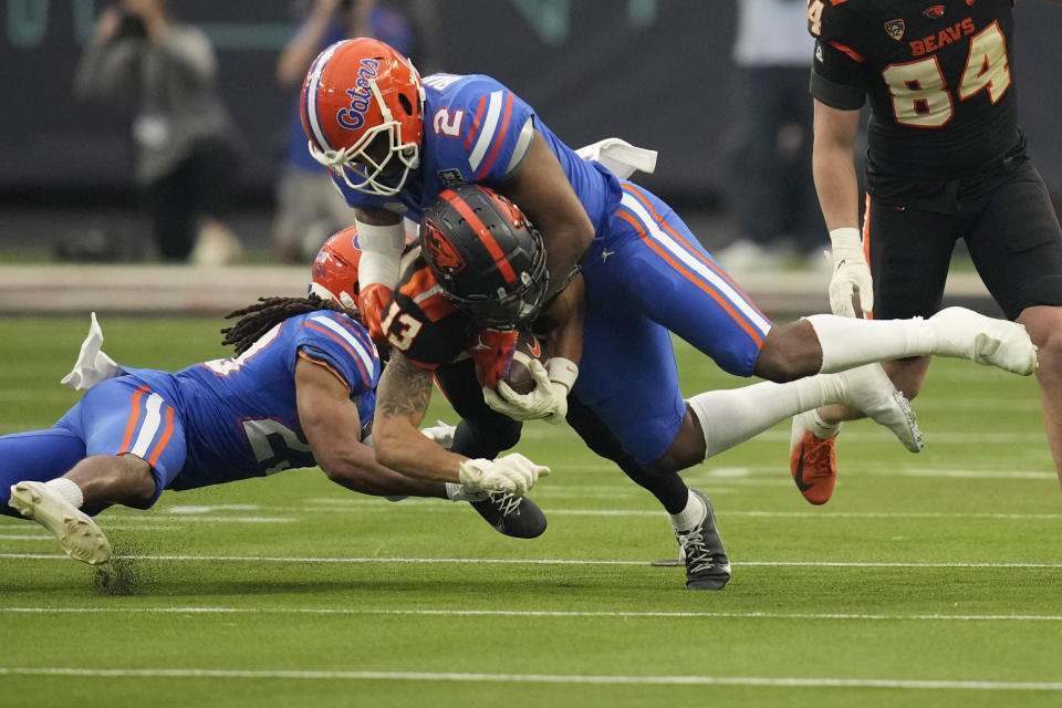 Florida linebacker Amari Burney (2) tackles Oregon State wide receiver Jesiah Irish (13) during the first half of the Las Vegas Bowl NCAA college football game Saturday, Dec. 17, 2022, in Las Vegas. (AP Photo/John Locher)