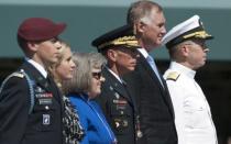 US Army General David Petraeus (3rd R) stands alongside his family, including children Stephen (L) and Anne (2nd R), and wife Holly (3rd L), as well as Admiral Mike Mullen (R), Chairman of the Joint Chiefs of Staff, and Deputy Secretary of Defense William Lynn (2nd R), during an Armed Forces Farewell Tribute and Retirement Ceremony in honor of Petraeus in Arlington, Virginia, in 2011