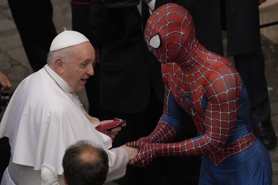 Pope Francis meets Spider-Man, who presents him with his mask, at the end of his weekly general audience with a limited number of faithful in the San Damaso Courtyard at the Vatican, Wednesday, June 23, 2021. The masked man works with sick children in hospitals. (AP Photo/Andrew Medichini)