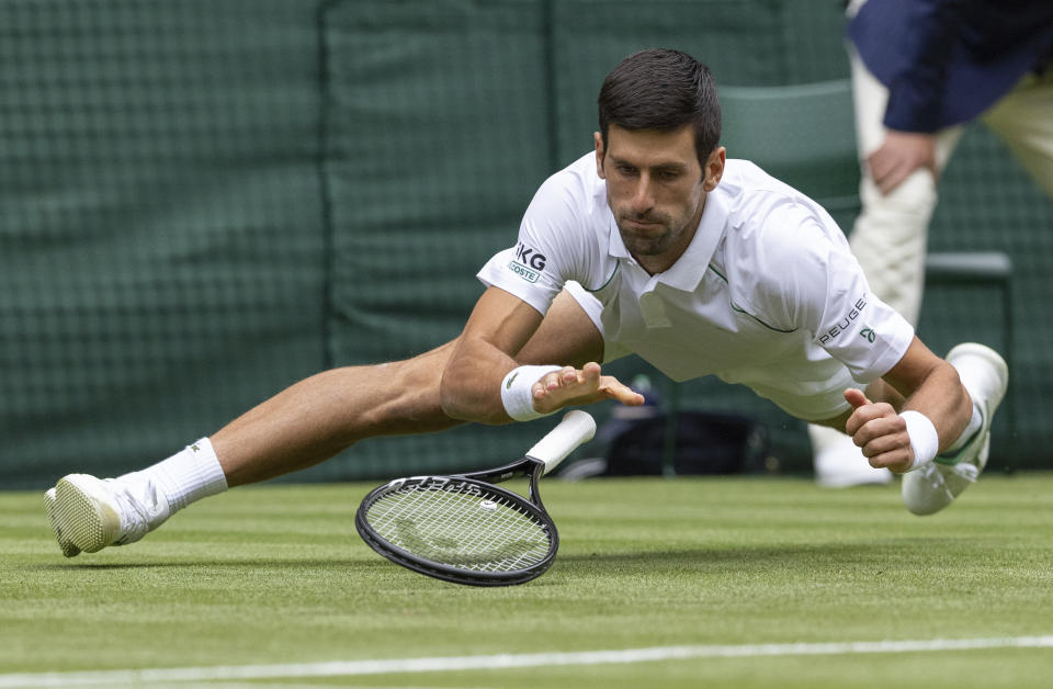 Novak Djokovic of Serbia falls whilst playing against South Africa's Kevin Anderson during the men's singles second round match on day three of the Wimbledon Tennis Championships in London, Wednesday June 30, 2021. (Ian Walton/Pool via AP)
