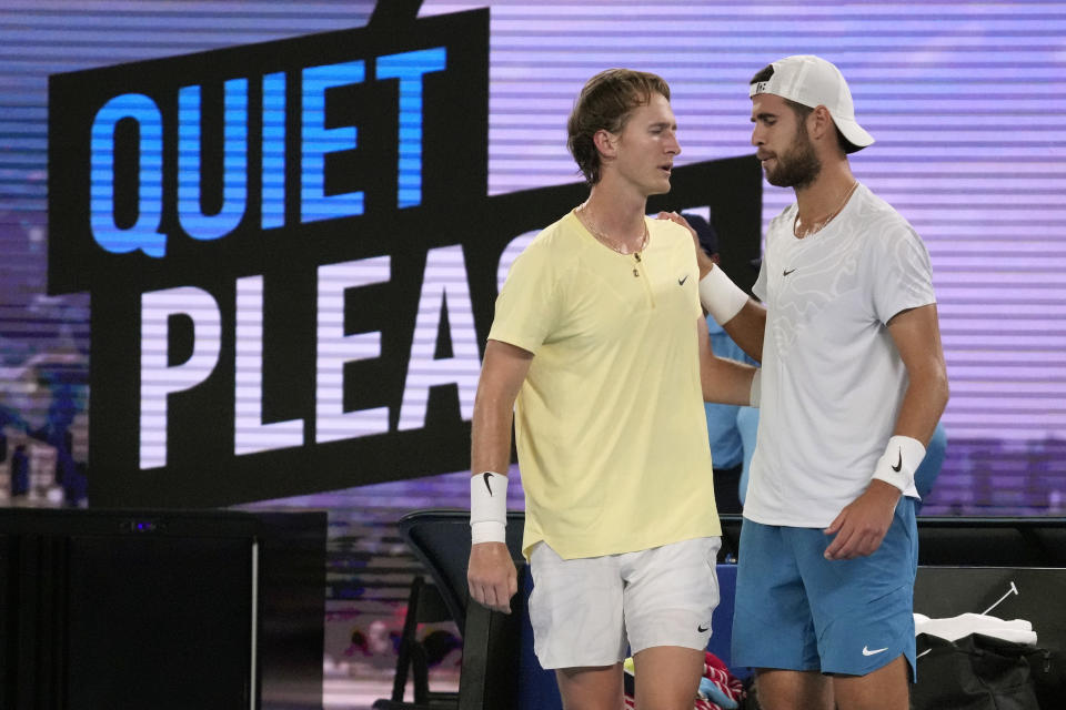 Karen Khachanov, right, of Russia gestures to Sebastian Korda of the U.S. after Korda withdrew from their match with an injured wrist during their quarterfinal match at the Australian Open tennis championship in Melbourne, Australia, Tuesday, Jan. 24, 2023. (AP Photo/Dita Alangkara)