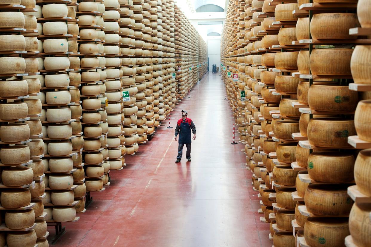 Man at work in aging warehouses of Parmesan cheese and Grana Padano cheese on January 01, 2012 in Fiorenzuola d'Arda, Italy.