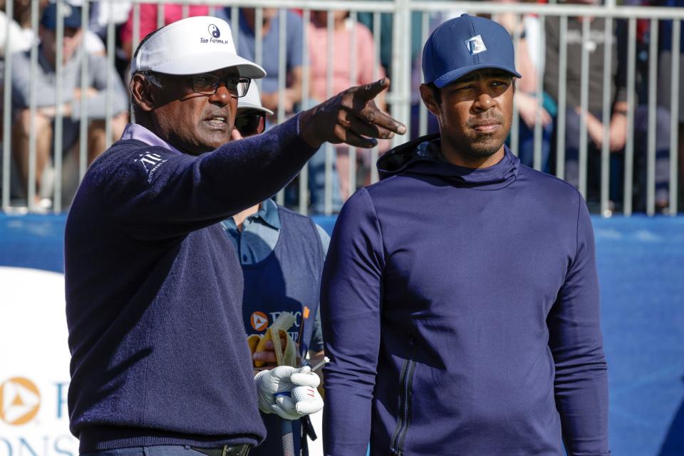 Vijay Singh (left) and his son Qass talk strategy on the first hole of the Ritz-Carlton Club Grande Lakes Course in Orlando during the first round of the PNC Championship on Saturday. They went on to win by two shots.