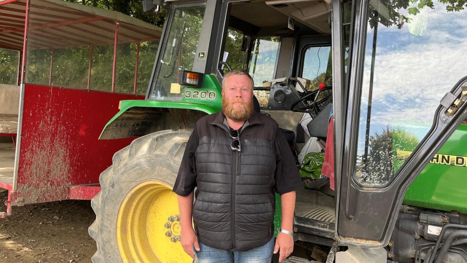 Peter Plummer beside the 'toast rack' tractor bus