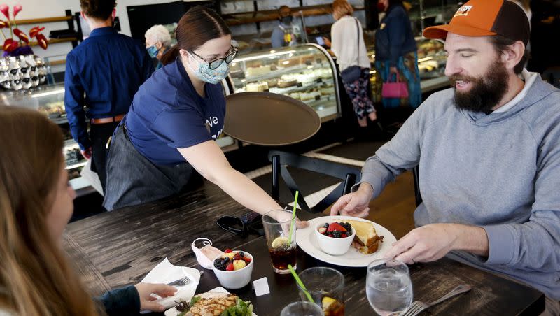 Eloise Schmitt serves lunch to Emma Larsen and her father, Shawn, at Gourmandise in Salt Lake City on April 8, 2021.