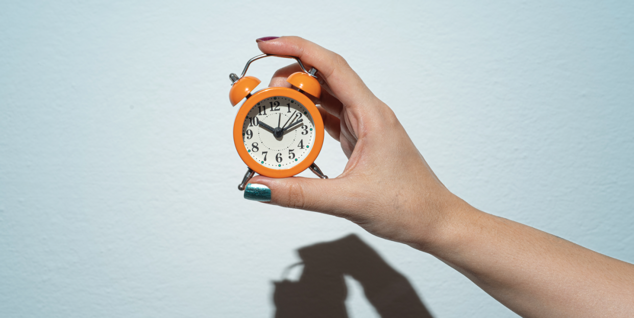 a hand holding a clock