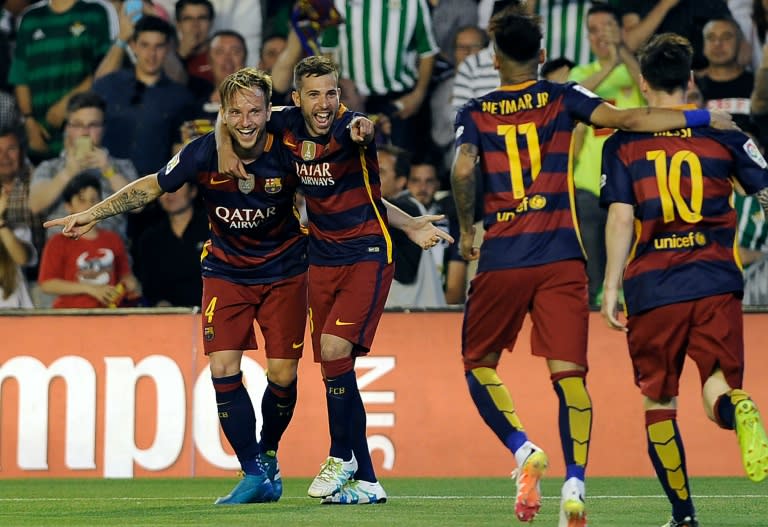 Barcelona's midfielder Ivan Rakitic (L) celebrates a goal with teammates during the Spanish league match against Real Betis in Sevilla on April 30, 2016