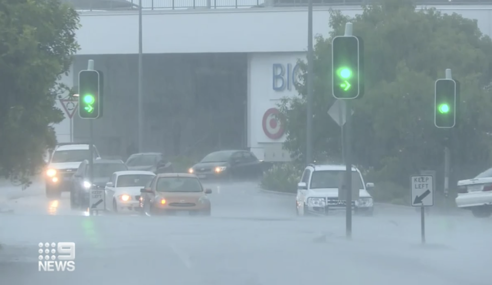 Cars drive through flooded roads in North Queensland.