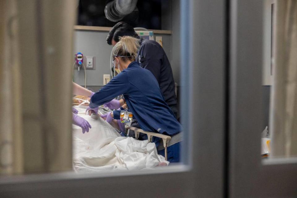 Medical workers in the emergency room at Saint Luke’s Hospital of Kansas City help a patient who suffered a heart attack this week. Emergency departments across the metro are busy during the omicron variant surge.