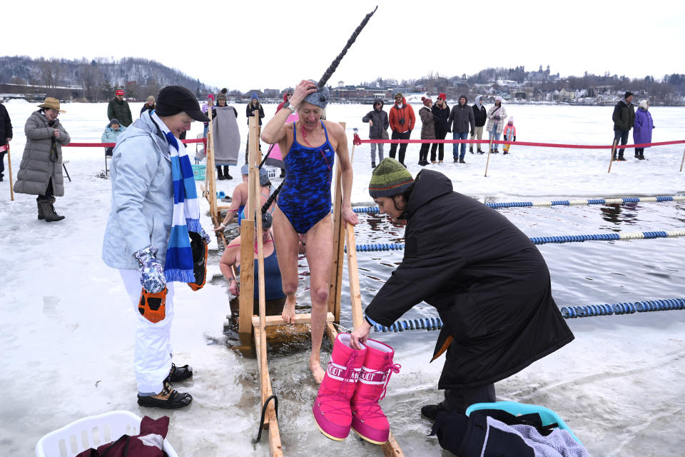 Charlotte Brynn steps barefooted onto the ice after her run during the 25 meter hat competition, part of the winter swimming festival, on frozen Lake Memphremagog, Friday, Feb. 23, 2024, in Newport, Vermont. (AP Photo/Charles Krupa)