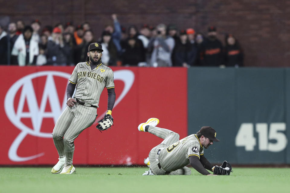 San Diego Padres' Jackson Merrill, right, makes a sliding catch on a ball hit by San Francisco Giants' Wilmer Flores in the eighth inning of a baseball game in San Francisco, Saturday, April 6, 2024. (AP Photo/Kavin Mistry)