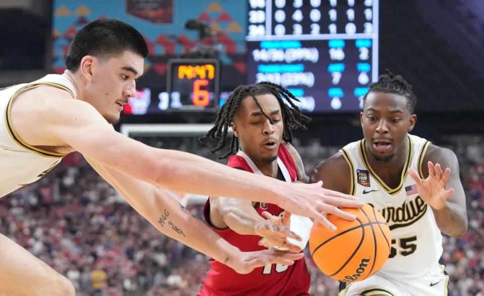 Purdue Boilermakers center Zach Edey (15), North Carolina State Wolfpack guard Breon Pass (10) and Purdue Boilermakers guard Lance Jones (55) go for the ball during the NCAA Men’s Basketball Tournament Final Four game, Saturday, April 6, 2024, at State Farm Stadium in Glendale, Ariz.