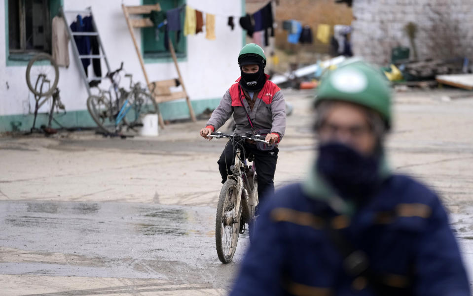 Vietnamese workers ride bicycles on their way to start their working day at the first Chinese car tire factory in Europe near the northern Serbian town of Zrenjanin, 50 kilometers north of Belgrade, Serbia, Thursday, Nov. 18, 2021. Reports have emerged in Serbia of prison-like conditions for some 500 of them at the construction site in north of the country where China's Shandong Linglong Tire Co is building the huge factory. Populist-run Serbia is a key spot for China's expansion and investment policies in Europe and Chinese companies have kept a tight lid on their projects in the country amid reports of disrespect of the Balkan nation's anti-pollution laws and labor regulations. (AP Photo/Darko Vojinovic)