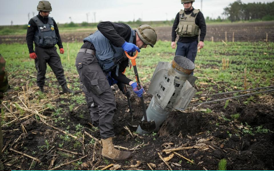 bomb disposal experts from the Ukrainian State Emergency Service make safe a Russian BM-30 Smerch rocket and remove it from a field - Christopher Furlong /Getty Images Europe 