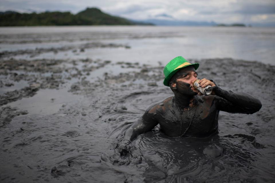 A reveller drinks beer as he takes part in the 