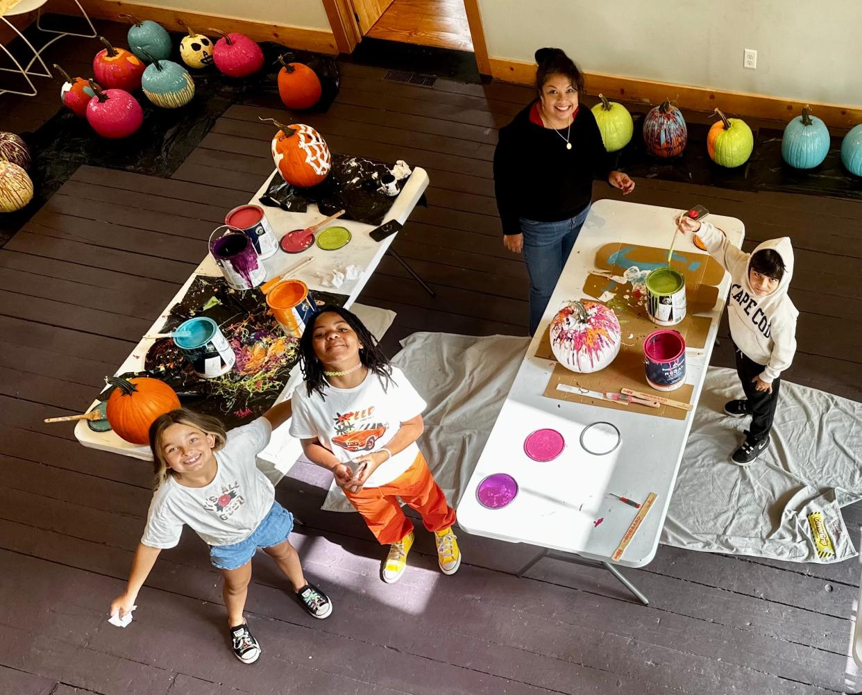 Kids paint pumpkins as part of an art class at the Guyer Art Barn in the fall.