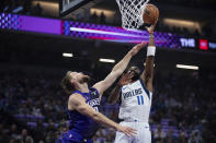 Dallas Mavericks guard Kyrie Irving (11) shoots over Sacramento Kings forward Domantas Sabonis (10) during the first half of an NBA basketball game in Sacramento, Calif., Tuesday, March 26, 2024. (AP Photo/José Luis Villegas)