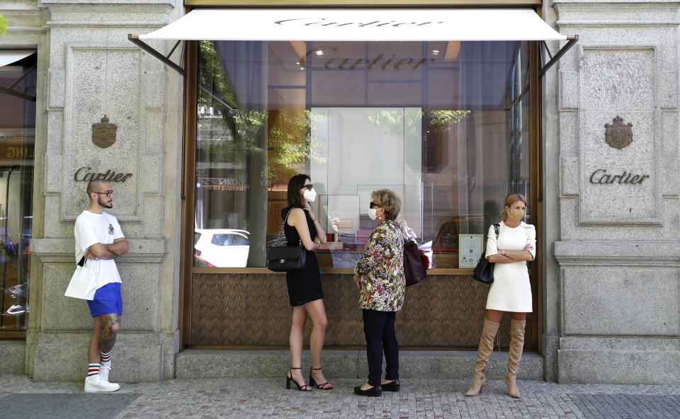 People wait in line in front of a shop in Prague, Czech Republic, Monday, May 10, 2021. The Czech Republic is massively relaxing its coronavirus restrictions as the hard-hit nation pay respect to nearly 30,000 dead. Monday's wave of easing came after the new infections fell to the levels unseen from August when the government failed to react in time to an opposite trend, the growing numbers of infected which later contributed to record numbers of deaths. (AP Photo/Petr David Josek)