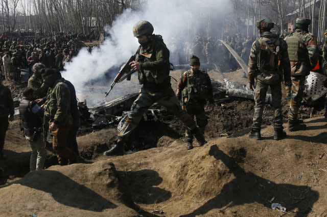 Indian army soldiers arrive near the wreckage of an Indian aircraft after it crashed in Budgam area, outskirts of Srinagar, Indian controlled Kashmir, Wednesday, Feb.27, 2019. (AP Photo/Mukhtar Khan)