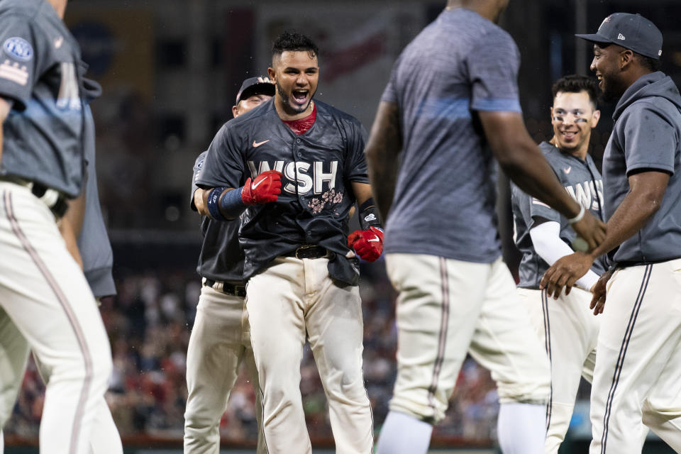 Washington Nationals' Keibert Ruiz, center, celebrates after hitting a walkoff home run during the ninth inning of a baseball game against the Oakland Athletics, Saturday, Aug. 12, 2023, in Washington. (AP Photo/Stephanie Scarbrough)