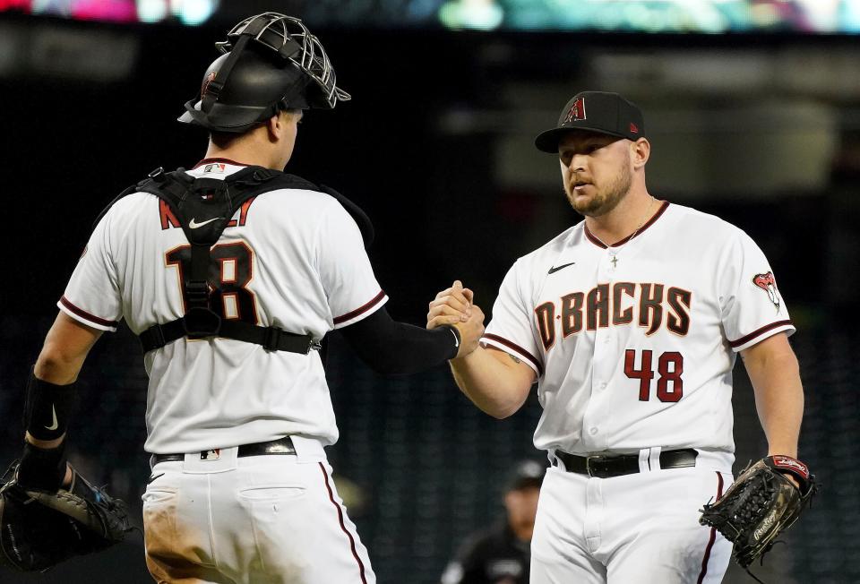 Arizona Diamondbacks catcher Carson Kelly (18) congratulates pitcher J.B. Wendelken (48), a South Effingham High School graduate, after closing out the Atlanta Braves in the ninth inning of a game Sept 23, 2021, in Phoenix.
