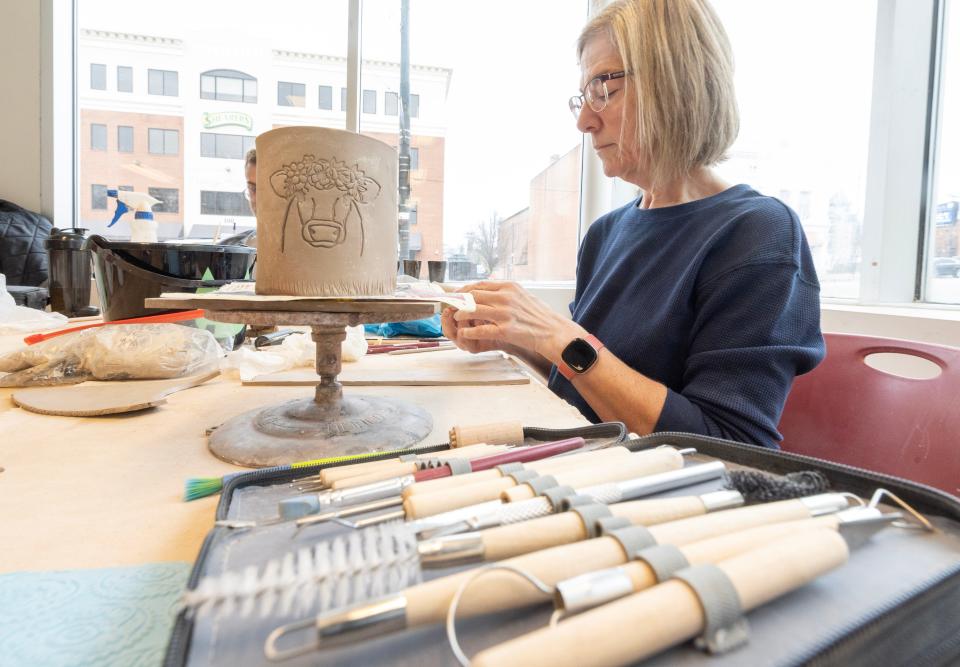 Carla Collmar works on a hand built ceramic mug in the Massillon Museum ceramics studio.