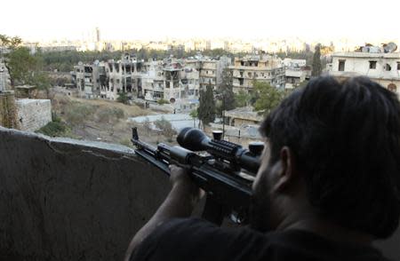 A Free Syrian Army fighter looks through the scope of his sniper rifle at an area controlled by forces loyal to Syria's President Bashar al-Assad in Aleppo's Al-Ezaa neighbourhood September 11, 2013. REUTERS/Aref Hretani