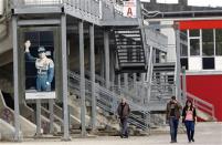 People walk near a picture of Brazilian Formula One driver Ayrton Senna at the race track in Imola April 22, 2014. REUTERS/Alessandro Garofalo