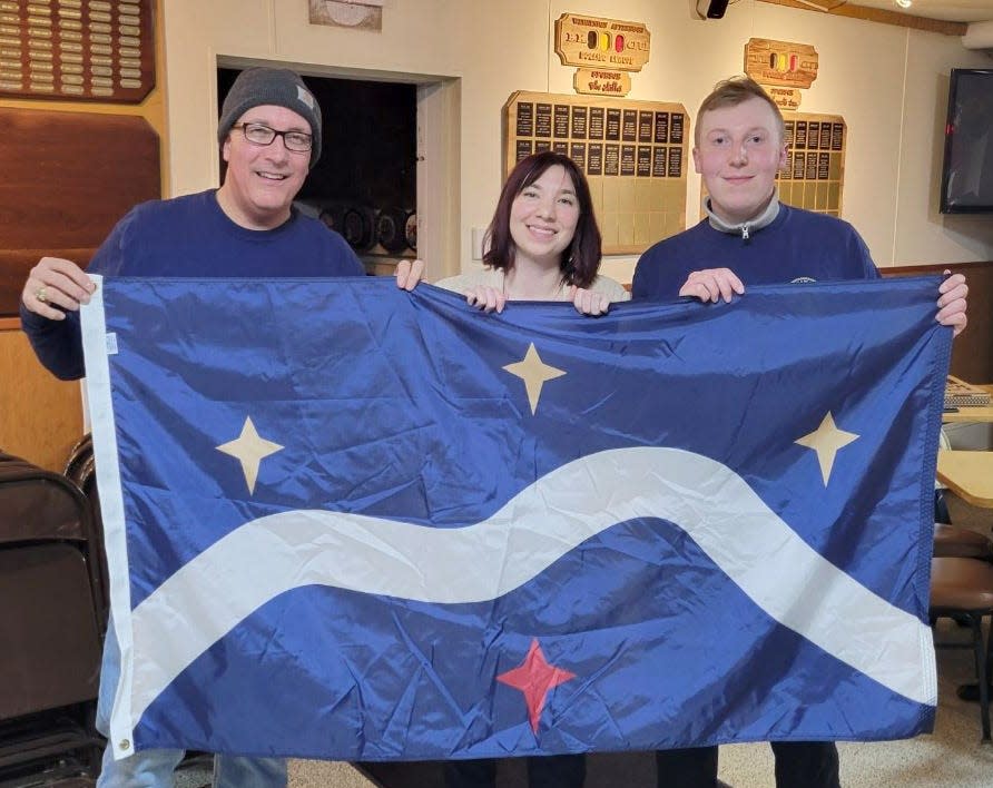 In this undated photo, Mishawaka Mayor Dave Wood joins Kelsey and Joshua Lange in holding up a version of a city of Mishawaka flag prototype the Lange sister-brother duo has designed. The two showed it to the Common Council in a presentation last month. The city is still gathering input on the proposal.