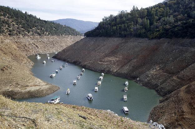 FILE - In this file photo taken Thursday, Oct. 30, 2014, houseboats sit in the drought lowered waters of Oroville Lake, near Oroville, Calif. Water levels dropped Monday, Feb. 13, 2017, at California's Lake Oroville, stopping water from spilling over a massive dam's potentially hazardous emergency spillway after authorities ordered the evacuation of people from towns lying below the lake. Lake Oroville also serves as a reservoir and levels rose significantly in recent weeks after a series of storms that have dumped rain and snow across California. (AP Photo/Rich Pedroncelli, File)