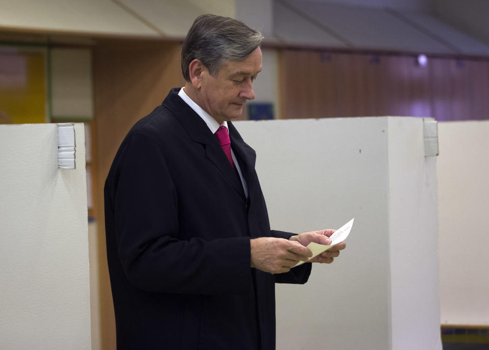 Slovenian President Danilo Turk holds his ballot to cast it at a polling station in Ljubljana, Slovenia, Sunday, Nov. 11, 2012. Three candidates, including Turk, are vying for the presidency in Slovenia, a tiny, economically troubled European Union nation that is riven by deep political divisions and is in danger of needing a bailout. (AP Photo/Darko Bandic)