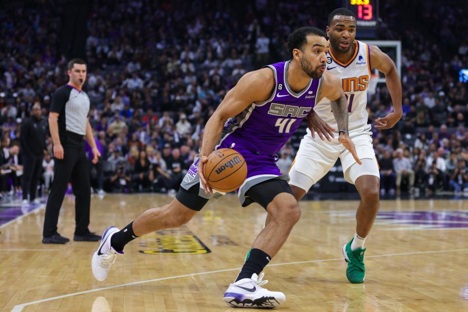 Sacramento Kings forward Trey Lyles (41) dribbles the ball around Phoenix Suns forward T.J. Warren (21) during the first quarter of a March 24, 2023, game at Golden 1 Center in Sacramento, Calif.