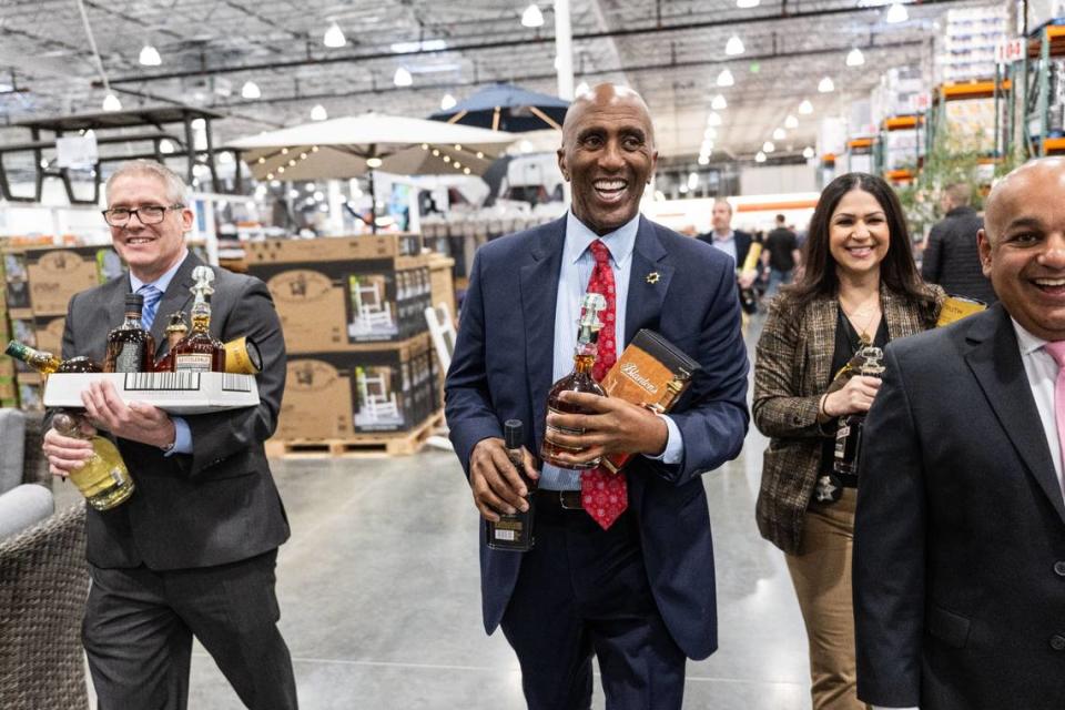 Sacramento County Sheriff Jim Cooper walks with some of the coveted liquor bottles during the grand opening of the Natomas Costco Wholesale on Thursday.