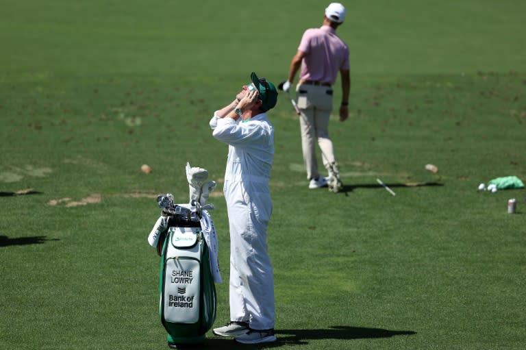 Caddie Darren Reynolds uses special glasses to view the eclipse during an Augusta National practice round ahead of the 88th Masters (Warren Little)