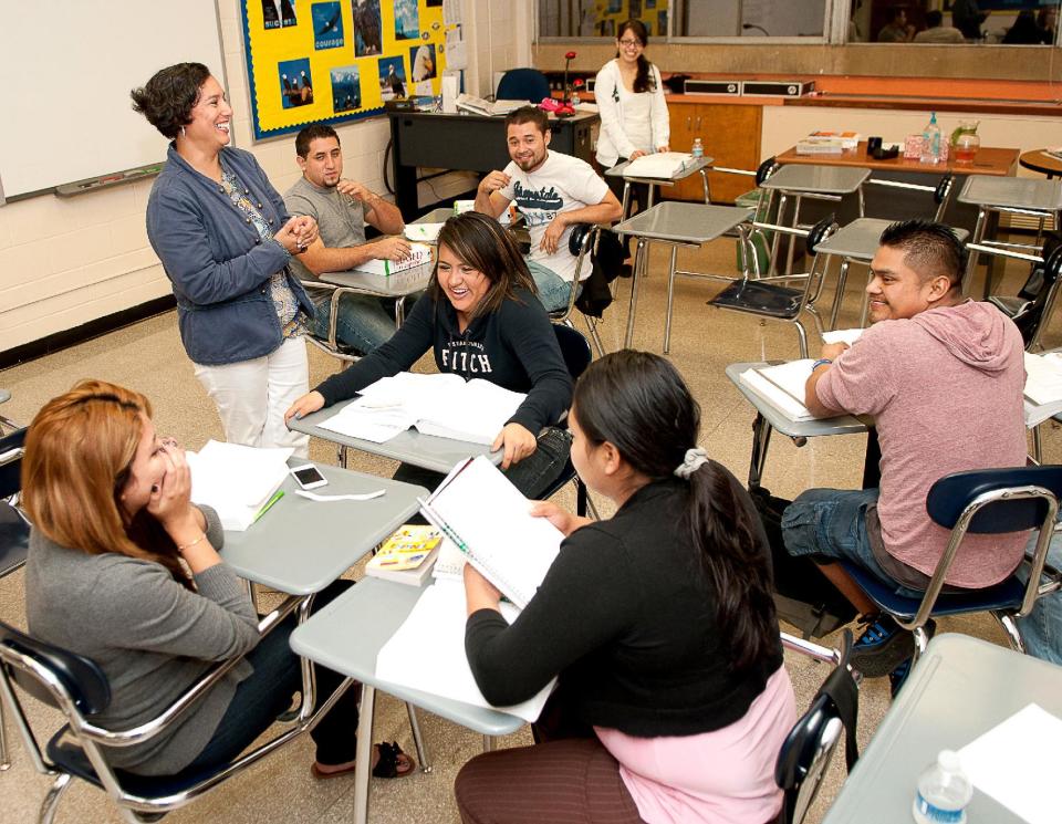 FILE - This Oct. 11, 2012 file photo shows Pilar Quinn, a volunteer, teaching a GED preparation class at Marist School in Atlanta, Ga. The GED test, the high school equivalency exam, is about to undergo some changes. On Thursday, Jan 2, 2014, an upgraded GED exam and two new competing equivalency tests offered in several states will usher in a new era in adult education testing. (AP Photo/Rebecca Breyer, File)