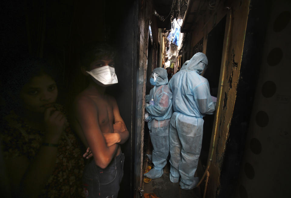 Indian health workers wearing personal protective equipment perform door to door check up during a check up camp at a slum in Mumbai, India, Wednesday, June 17, 2020. India is the fourth hardest-hit country by the COVID-19 pandemic in the world after the U.S., Russia and Brazil. (AP Photo/Rafiq Maqbool)