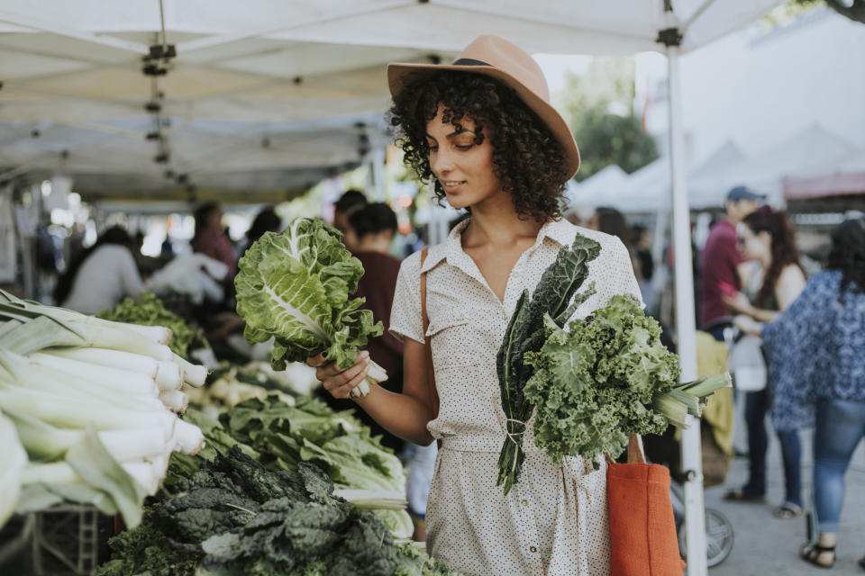 A woman holding produce at a farmer's market