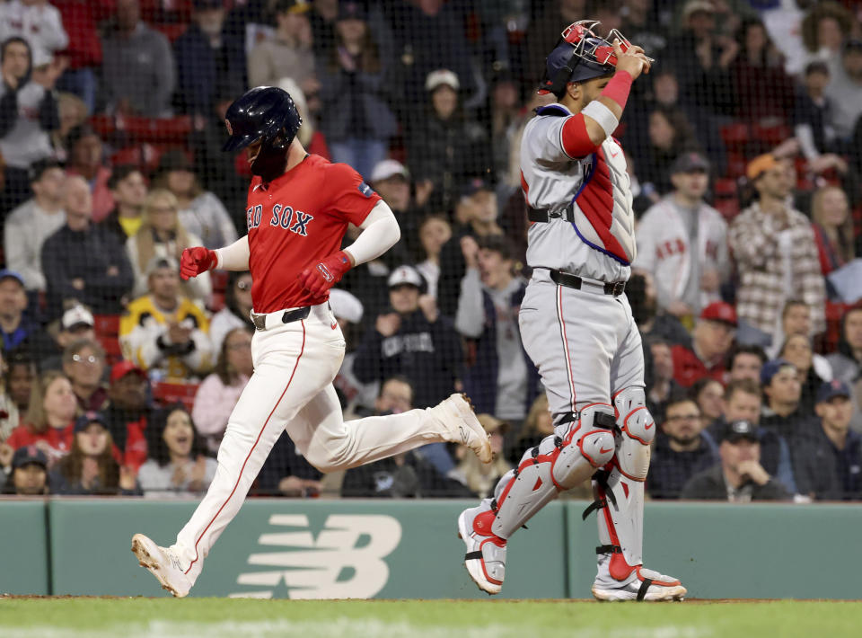 Boston Red Sox's Connor Wong, left, runs past Washington Nationals catcher Keibert Ruiz to score during the fourth inning of a baseball game Friday, May 10, 2024, in Boston. (AP Photo/Mark Stockwell)
