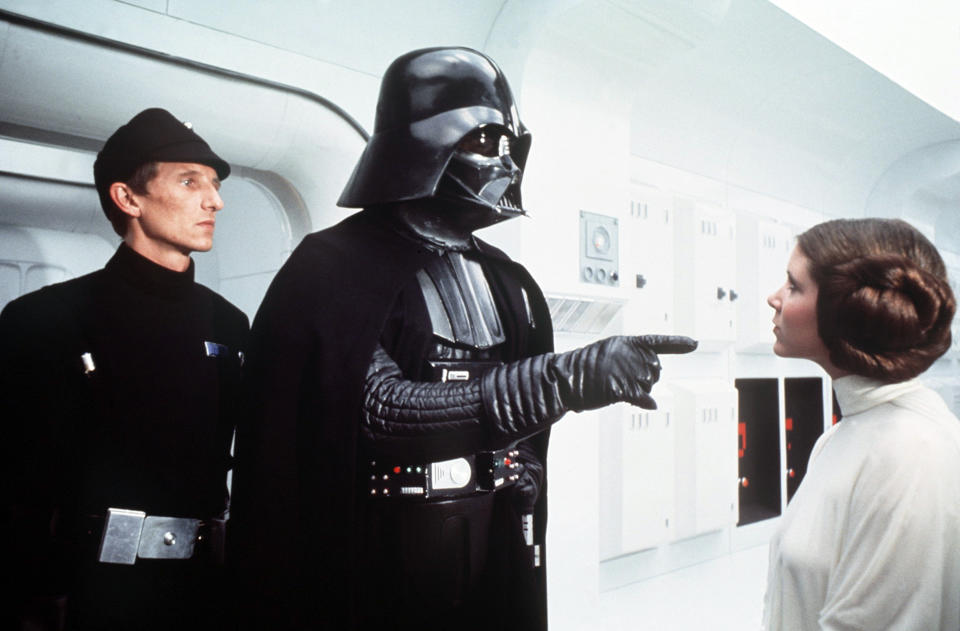 British actor David Prowse and American actress Carrie Fisher on the set of Star Wars: Episode IV - A New Hope written, directed and produced by Georges Lucas. (Photo by Sunset Boulevard/Corbis via Getty Images)