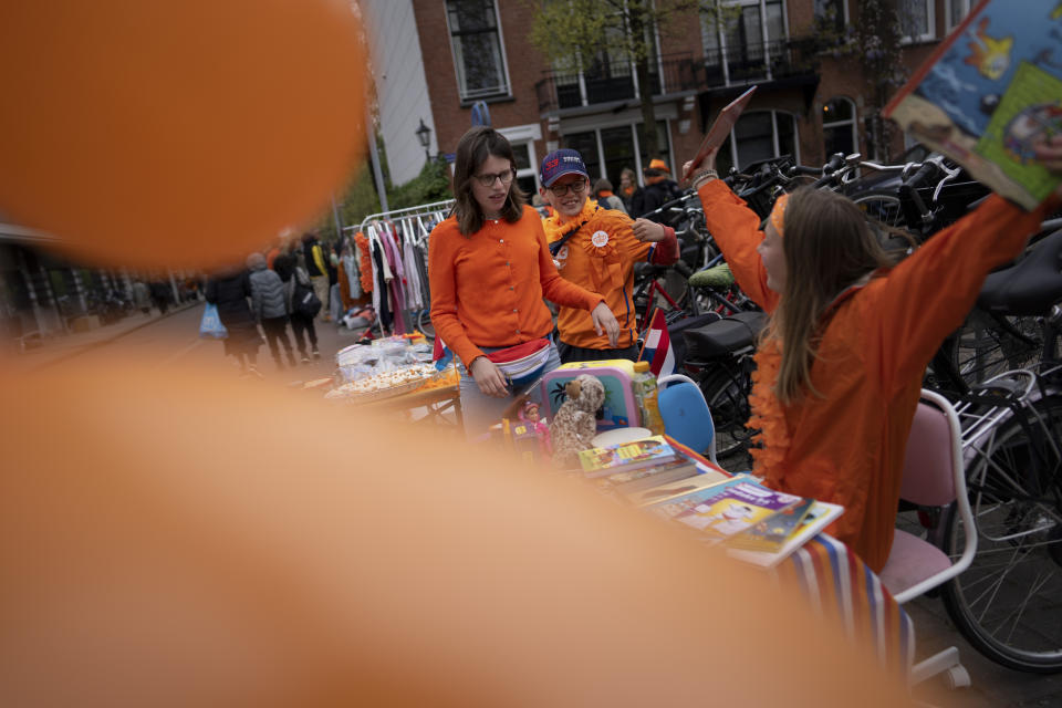 Orange-clad children sell books on a "free market" during King's Day celebrations in Amsterdam, Netherlands, Wednesday, April 27, 2022. After two years of celebrations muted by coronavirus lockdowns, the Netherlands marked the 55th anniversary of King Willem-Alexander of the House of Orange with street parties, music festivals and a national poll showing trust in the monarch ebbing away. (AP Photo/Peter Dejong)