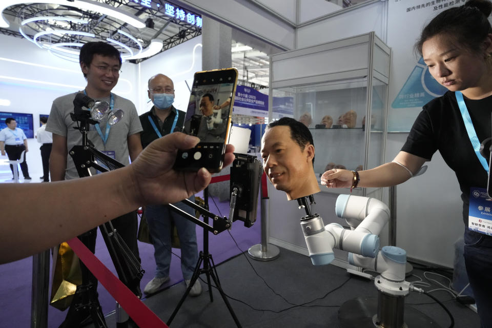 A visitor films a life-like head used to test biometric technologies to combat fraud during the Security China 2023 in Beijing, on June 7, 2023. After years of breakneck growth, China's security and surveillance industry is now focused on shoring up its vulnerabilities to the United States and other outside actors, worried about risks posed by hackers, advances in artificial intelligence and pressure from rival governments. The renewed emphasis on self-reliance, combating fraud and hardening systems against hacking was on display at the recent Security China exhibition in Beijing. (AP Photo/Ng Han Guan)