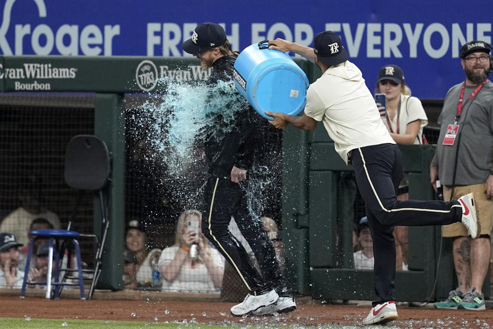 Texas Rangers' Jon Gray, left, is doused by Martin Perez, right, after their baseball game against the Seattle Mariners, Friday, June 2, 2023, in Arlington, Texas. (AP Photo/Tony Gutierrez)