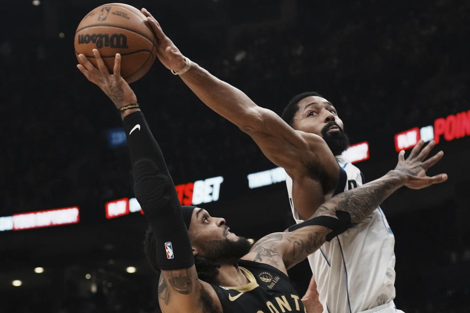 Toronto Raptors' Gary Trent Jr., left, shoots as Dallas Mavericks' Spencer Dinwiddie, right, defends during first-half NBA basketball game action in Toronto, Saturday, Nov. 26, 2022. (Chris Young/The Canadian Press via AP)