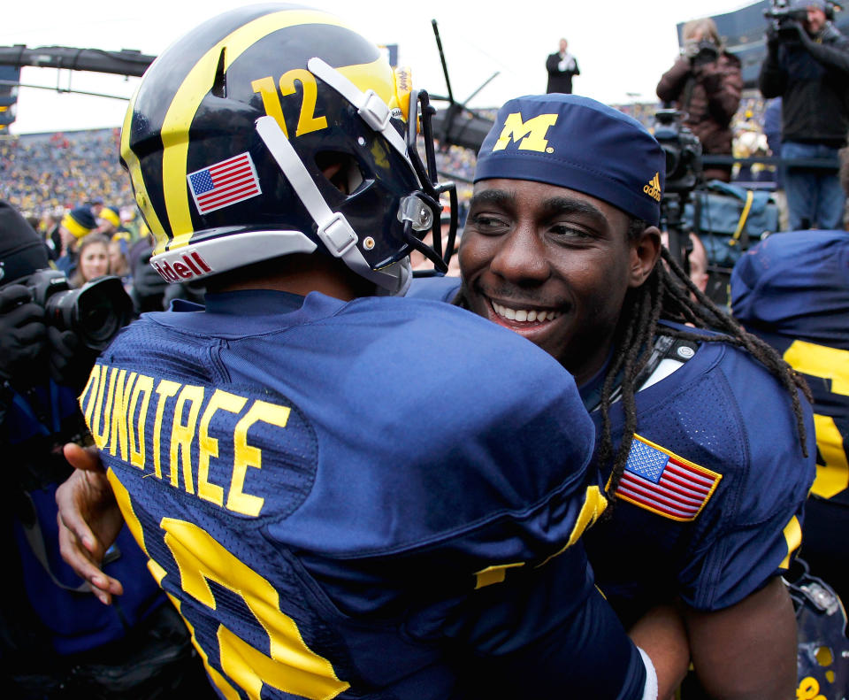 Denard Robinson of the Michigan Wolverines celebrates a 45-17 victory over the Nebraska Cornhuskers with Roy Roundtree at Michigan Stadium on November 19, 2011 in Ann Arbor, Michigan. (Photo by Gregory Shamus/Getty Images)